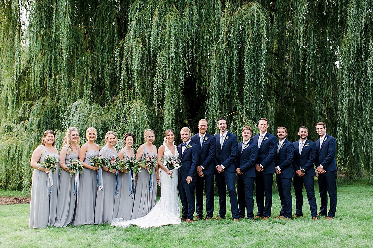 It wedding party portrait by a willow tree at Aurora Cellars in Michigan