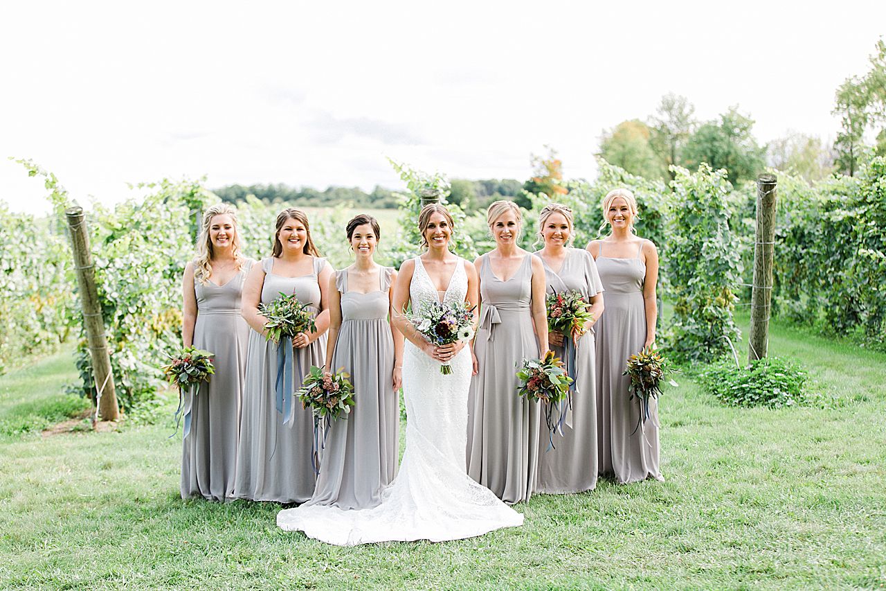 A bride with her bridesmaids near a vineyard at Aurora Cellars