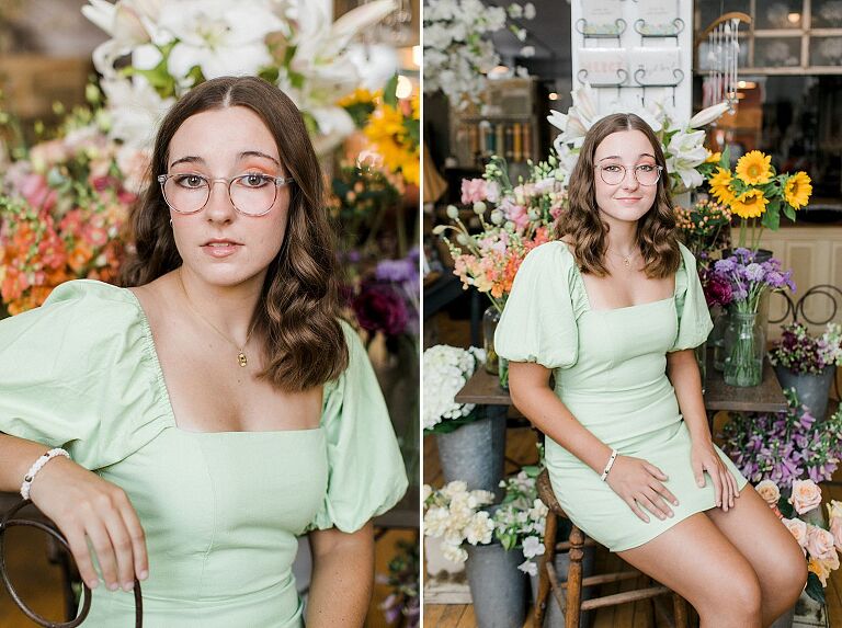 A senior portrait session in Charlevoix, Michigan with a girl wearing a green dress and glasses in a floral shop