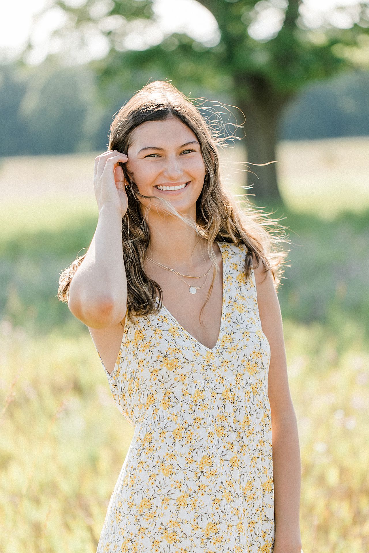 A girl wearing a yellow floral dress on a sunny summer evening in Northern Michigan