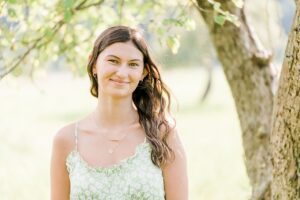 A senior portrait of a girl in a light green dress during her portrait session in Empire, Michigan