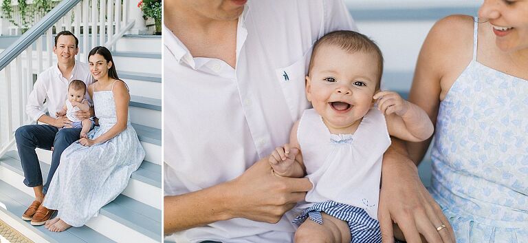 A baby laughing while sitting on her parents laps on porch in Harbor Springs, Michigan