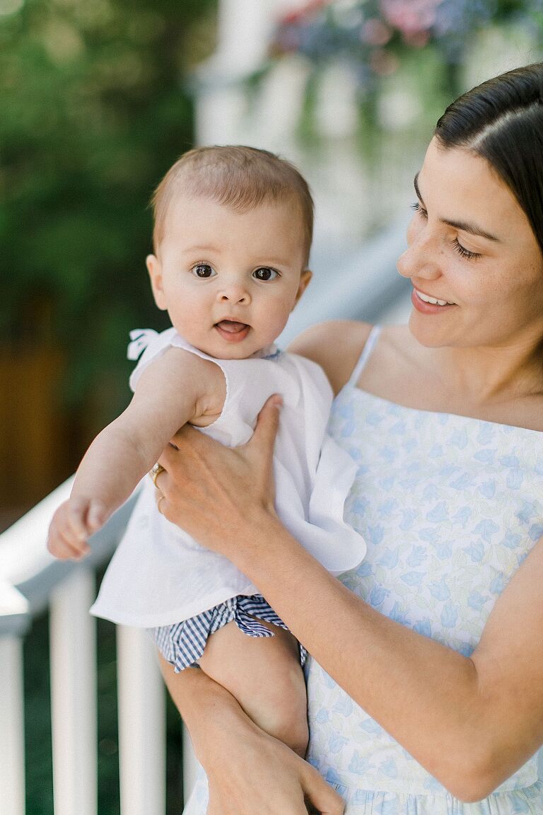 A baby girl being held my her mother in the summer in Michigan