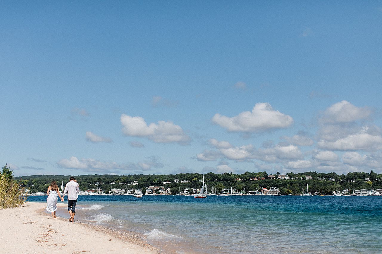 A family of three walking along Little Traverse Bay in Harbor Springs, Michigan
