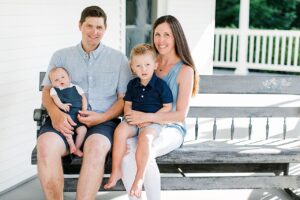 A portrait of a family of 4 in Northern Michigan on a white porch