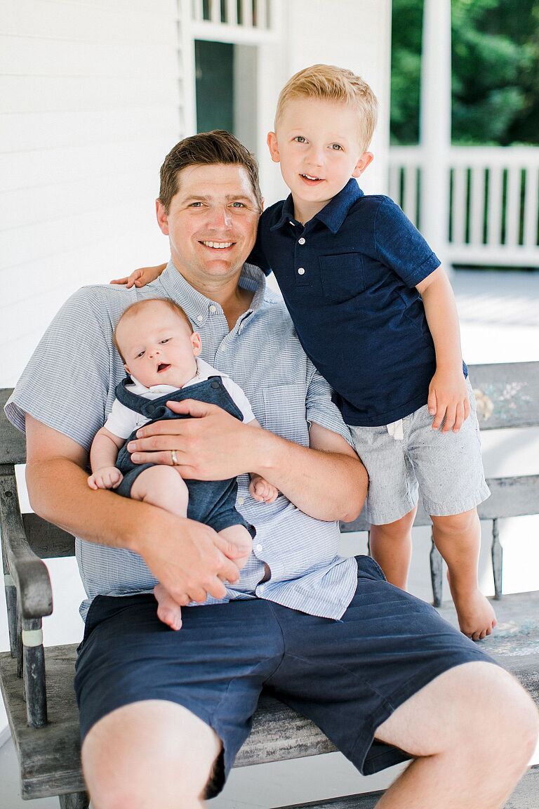 A portrait of a father and his two sons in Petoskey, Michigan on a white porch