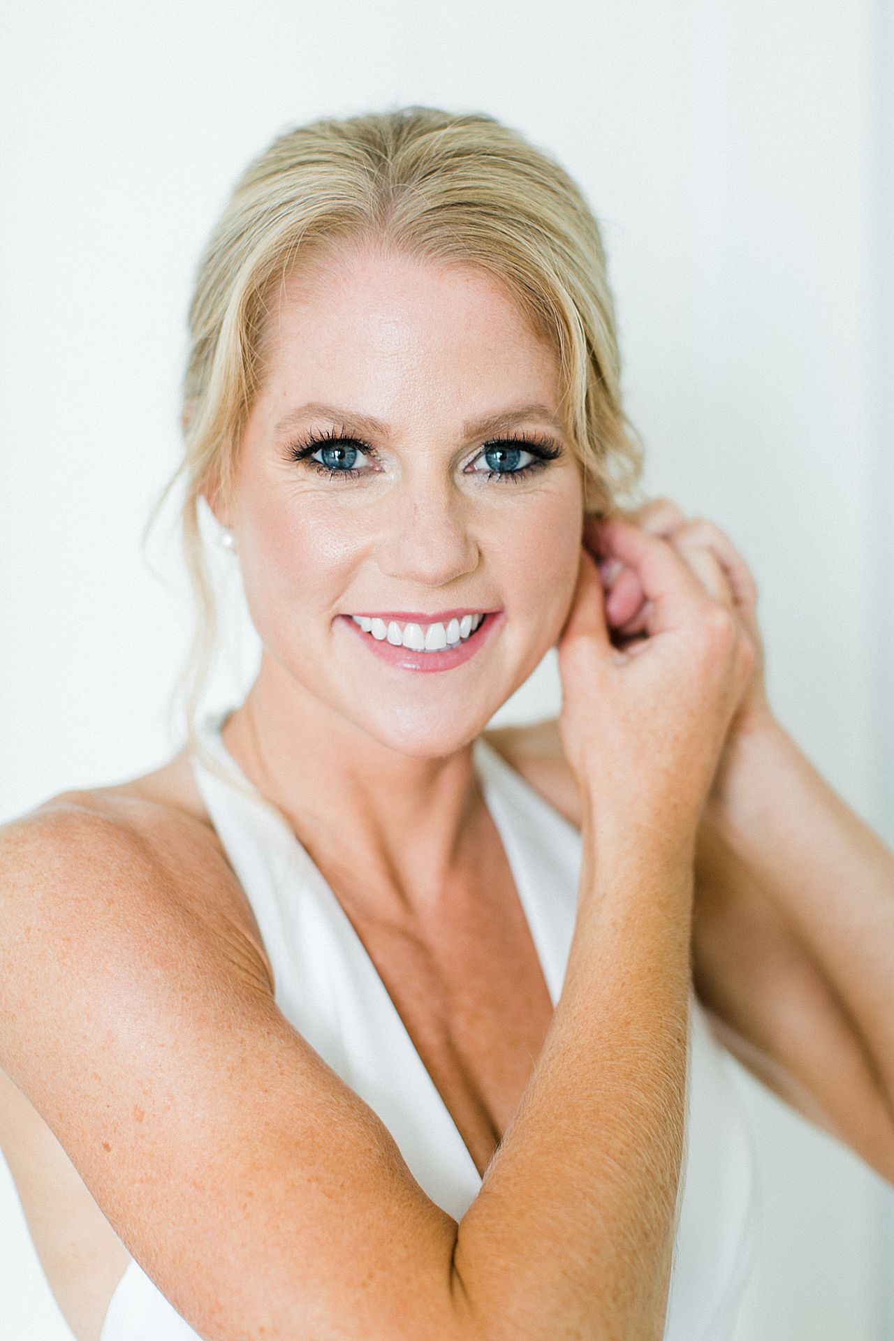 A bride putting on her earrings in Bay Harbor, Michigan