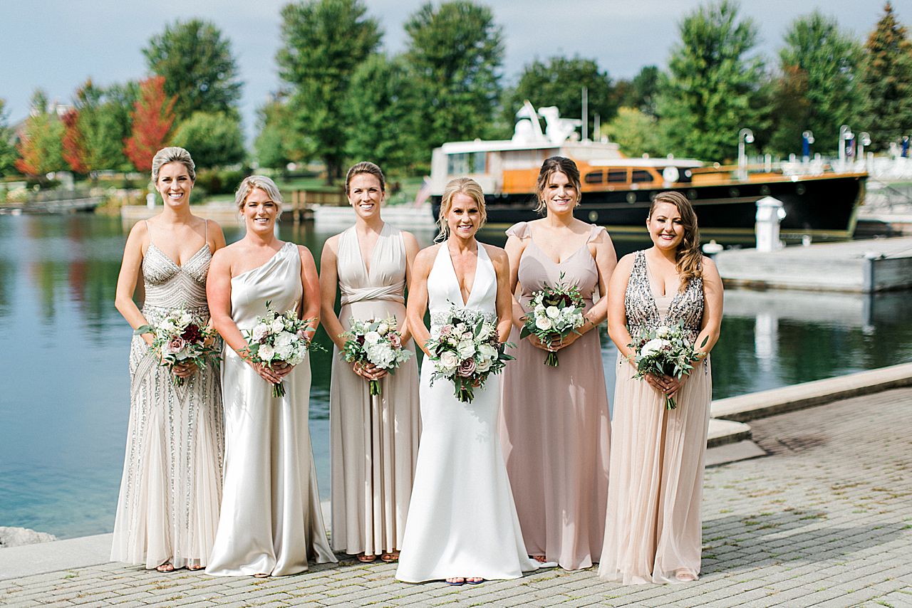 A bride and her bridesmaids by the water in Bay Harbor, Michigan