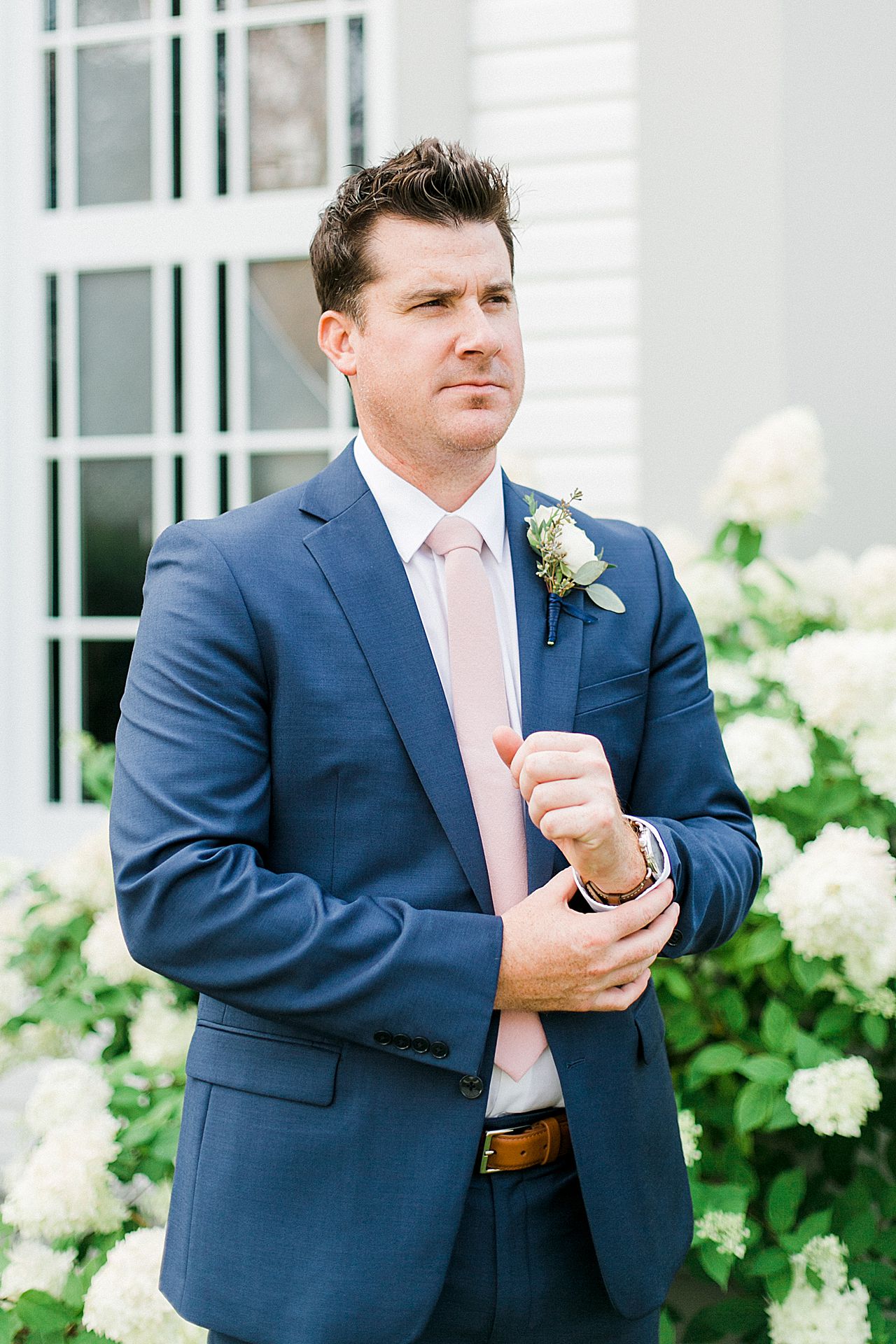 A groom portrait in front of Holy Childhood of Jesus Catholic Church in Harbor Springs, Michigan