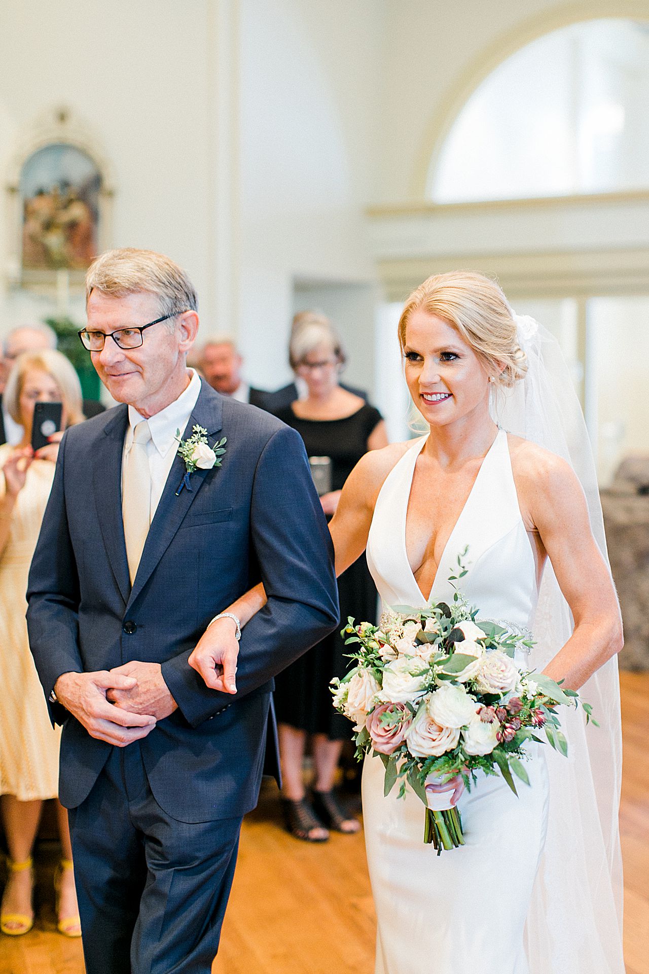 A bride walking towards her groom at a Catholic Church in Harbor Springs, Michigan