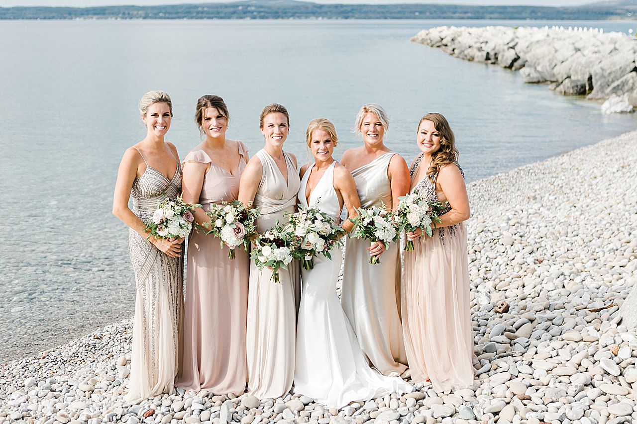 A portrait of a bride and her bridesmaids on little traverse bay in Petoskey, Michigan