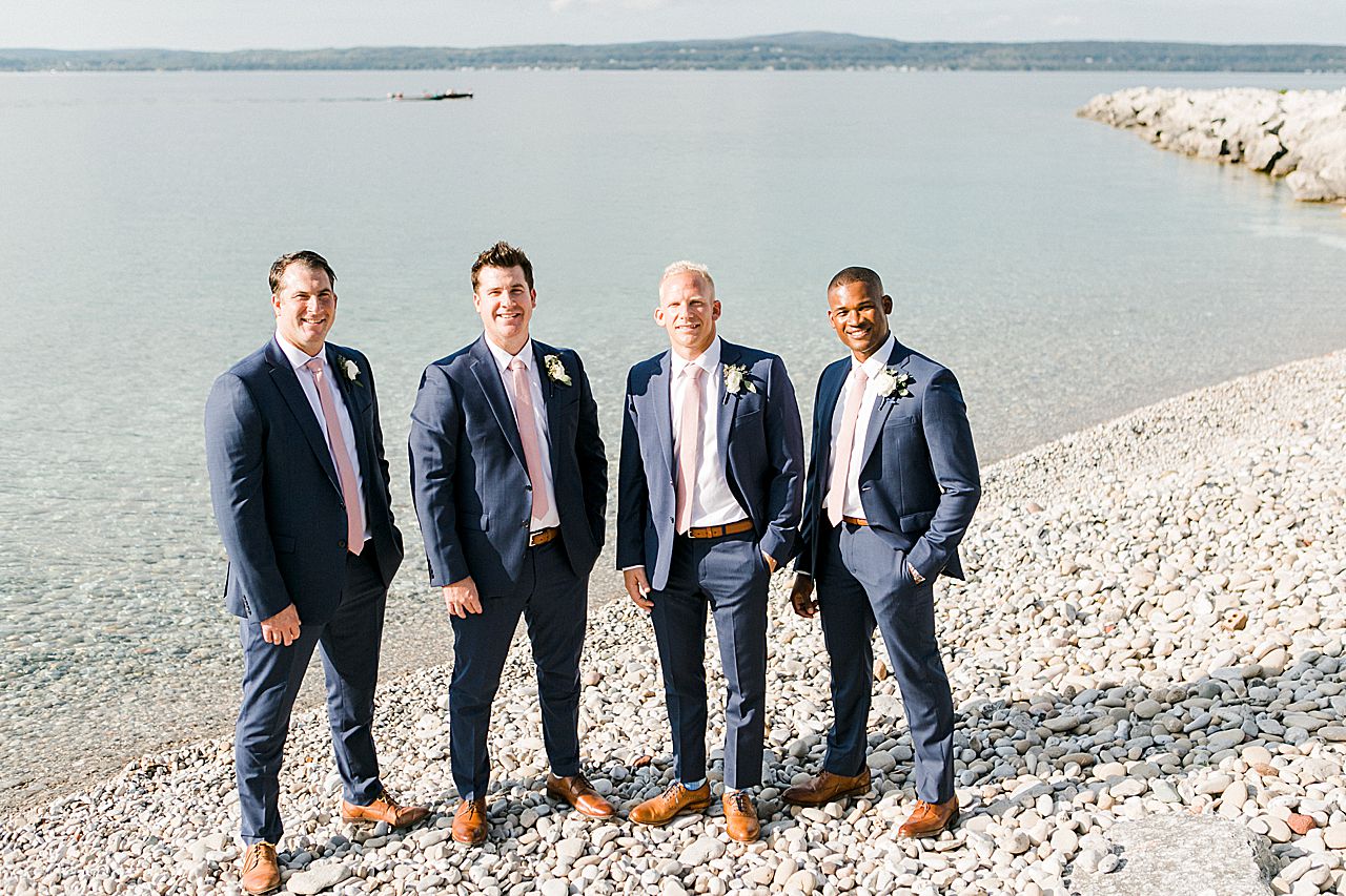 A portrait of a groom and his groomsmen in Petoskey, Michigan by the water