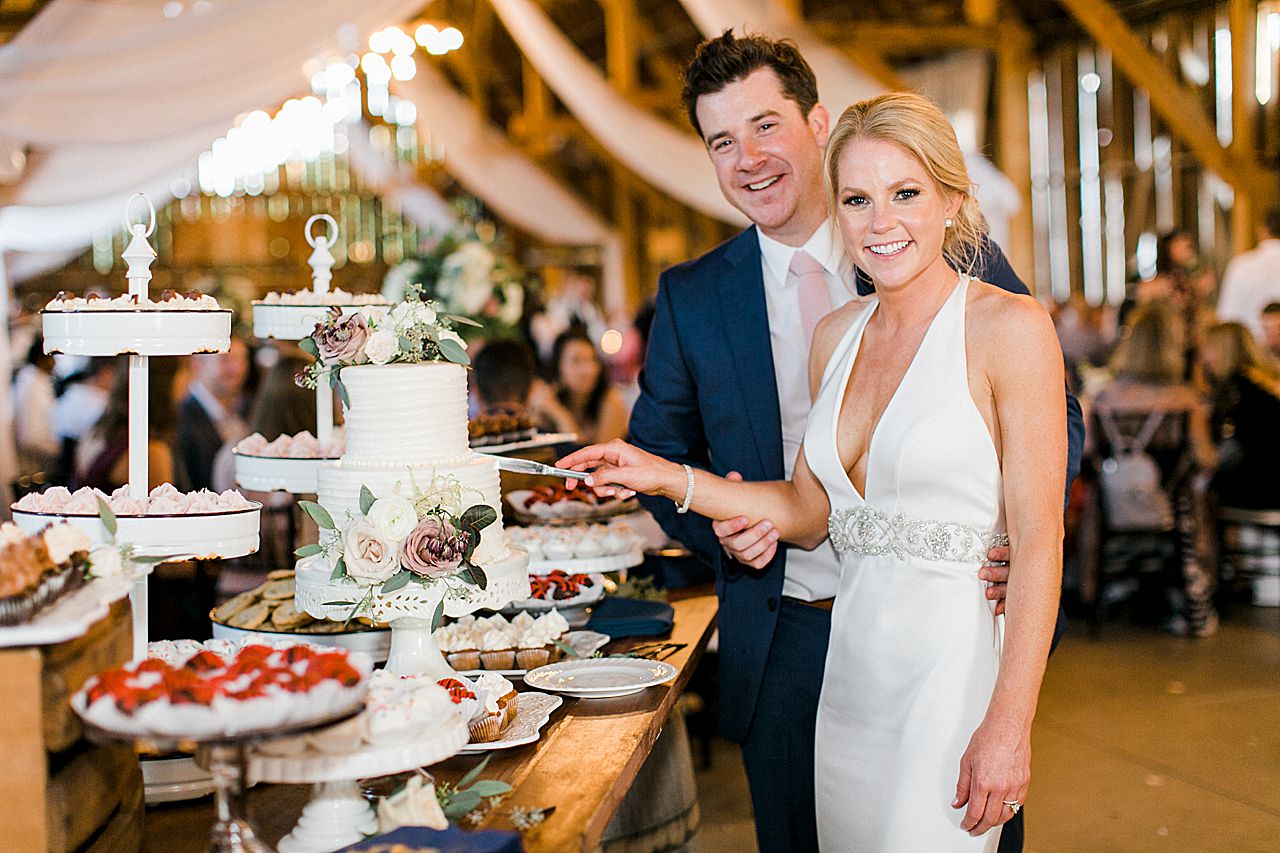 A bride and groom cutting their wedding cake at their wedding reception in Charlevoix, Michigan