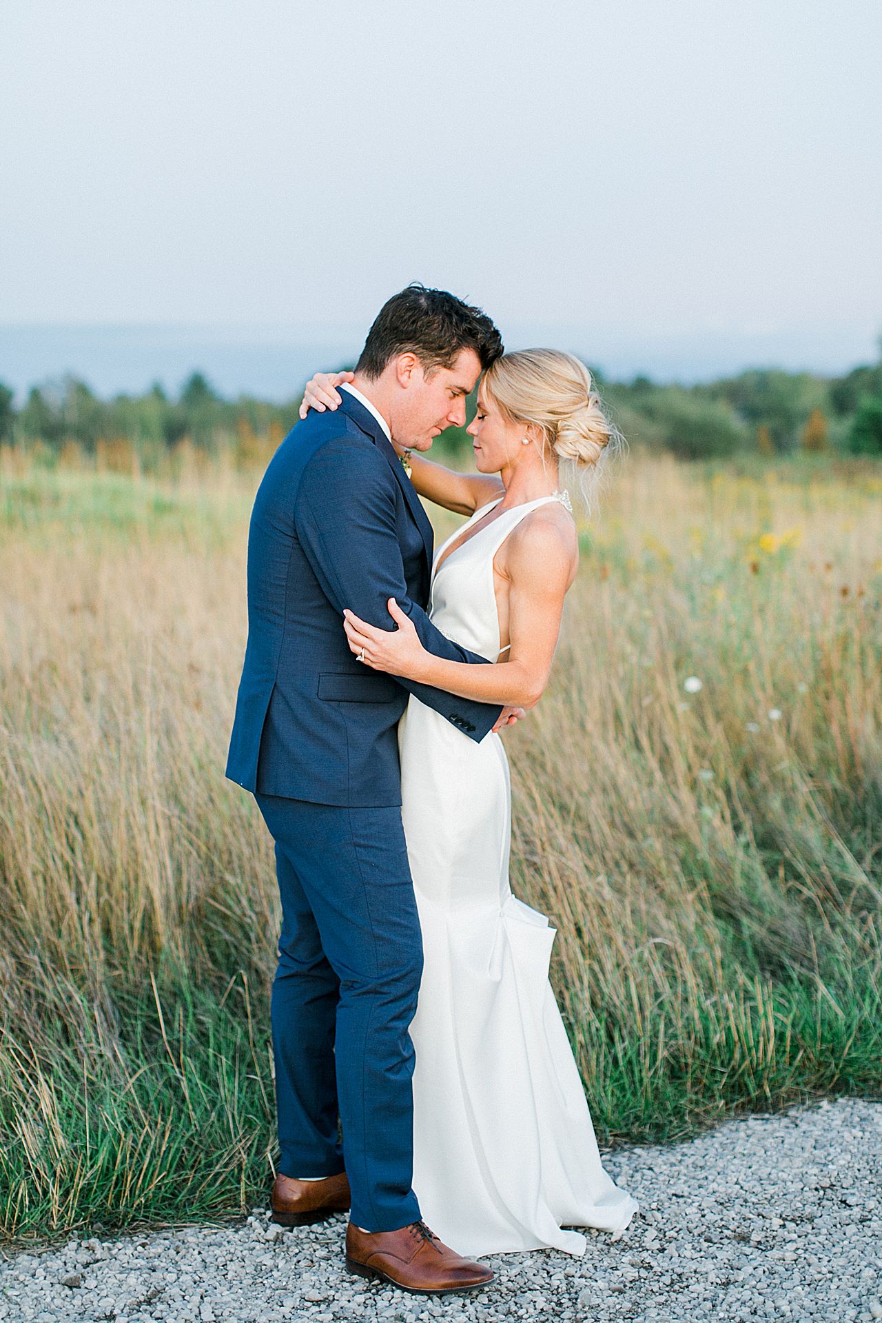 A bride and groom portraits in a field at sunset in Northern Michigan