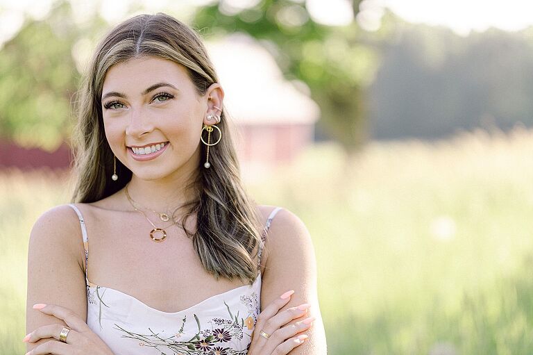 A high school senior girl taking portraits with a white dress on in Northern Michigan