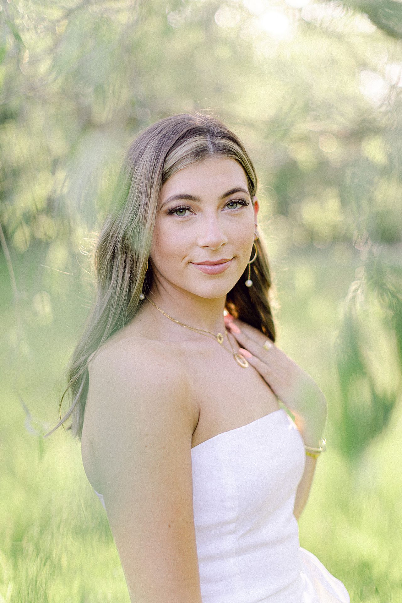 A portrait of a high school senior girl in a willow tree in Michigan