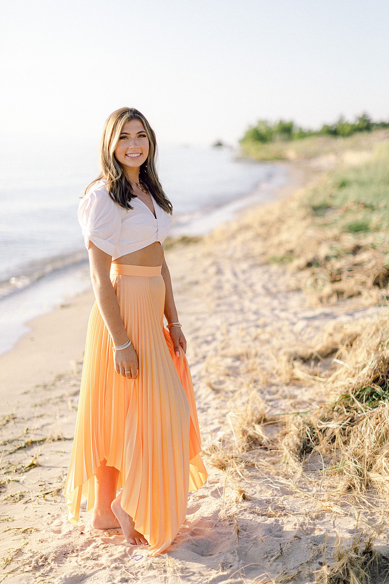 A high school senior standing along the Lake Michigan shoreline