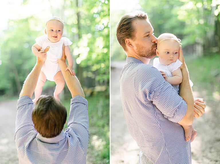 A father holding his baby daughter along a trail in the woods in Charlevoix, Michigan