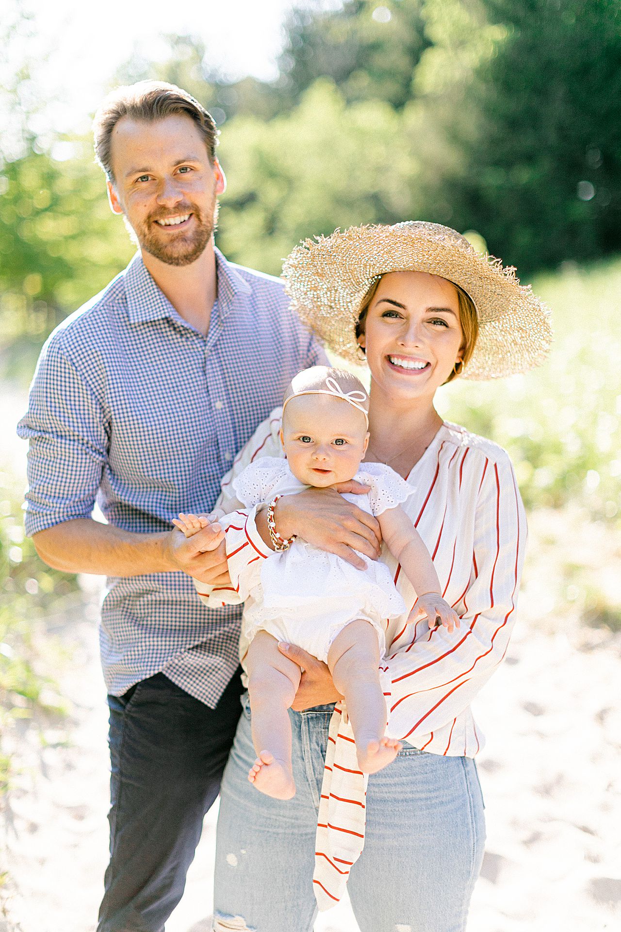 A family of 3 on a sunny day at Mt. McSauba with trees and dunes in the background