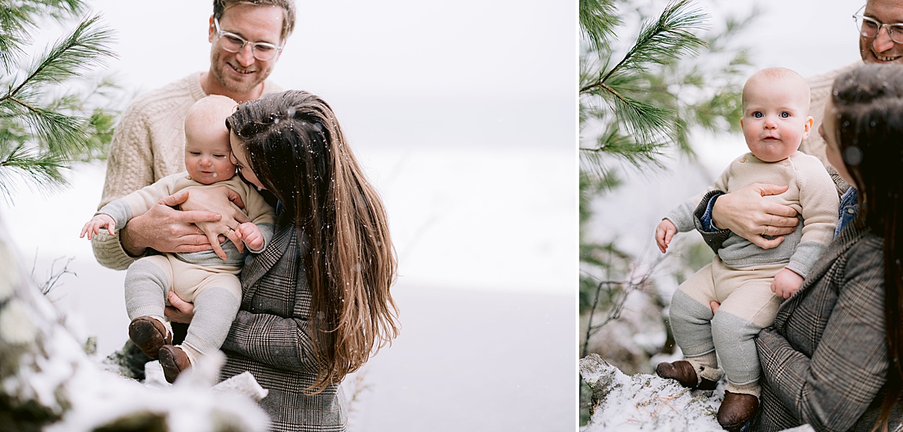 A baby being snuggles by his mother in the snowy woods in Michigan
