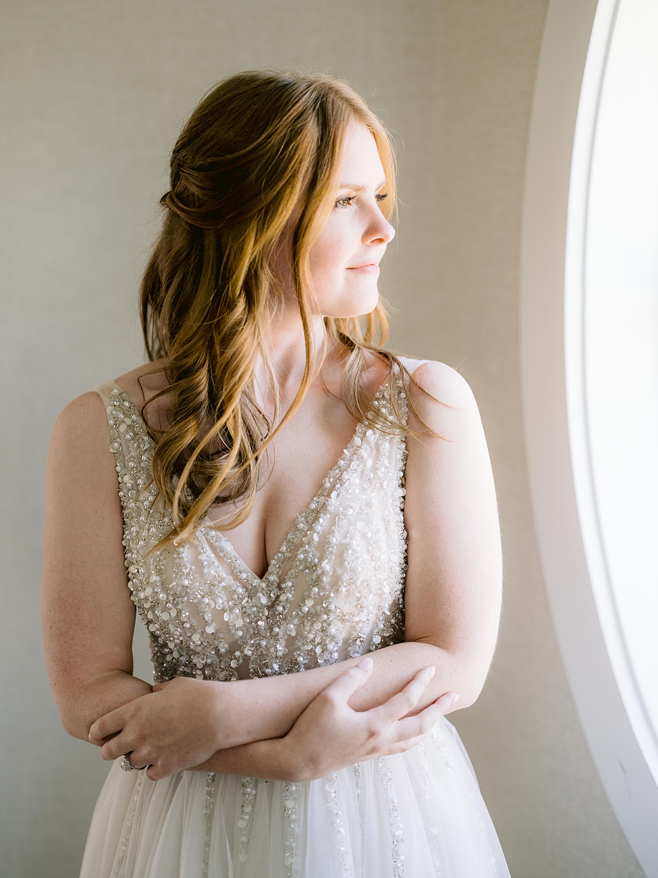 Portrait of a bride's profile looking out of a window.