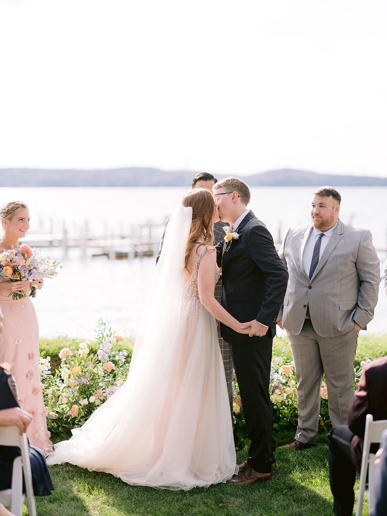 A bride and groom sharing their first kiss as a married couple in the sunshine of Northern Michigan.