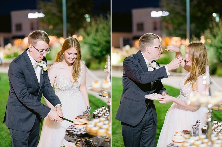 A bride and groom cutting wedding cake together and feeding each other a bite.