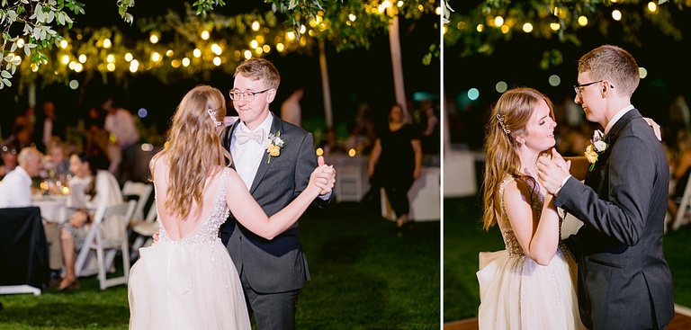 A bride and groom dancing under party lights and greenery at night with guests in the background.