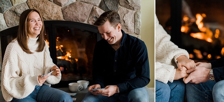 An engaged couple sitting by a fire drinking hot chocolate in Mullett Lake, Michigan