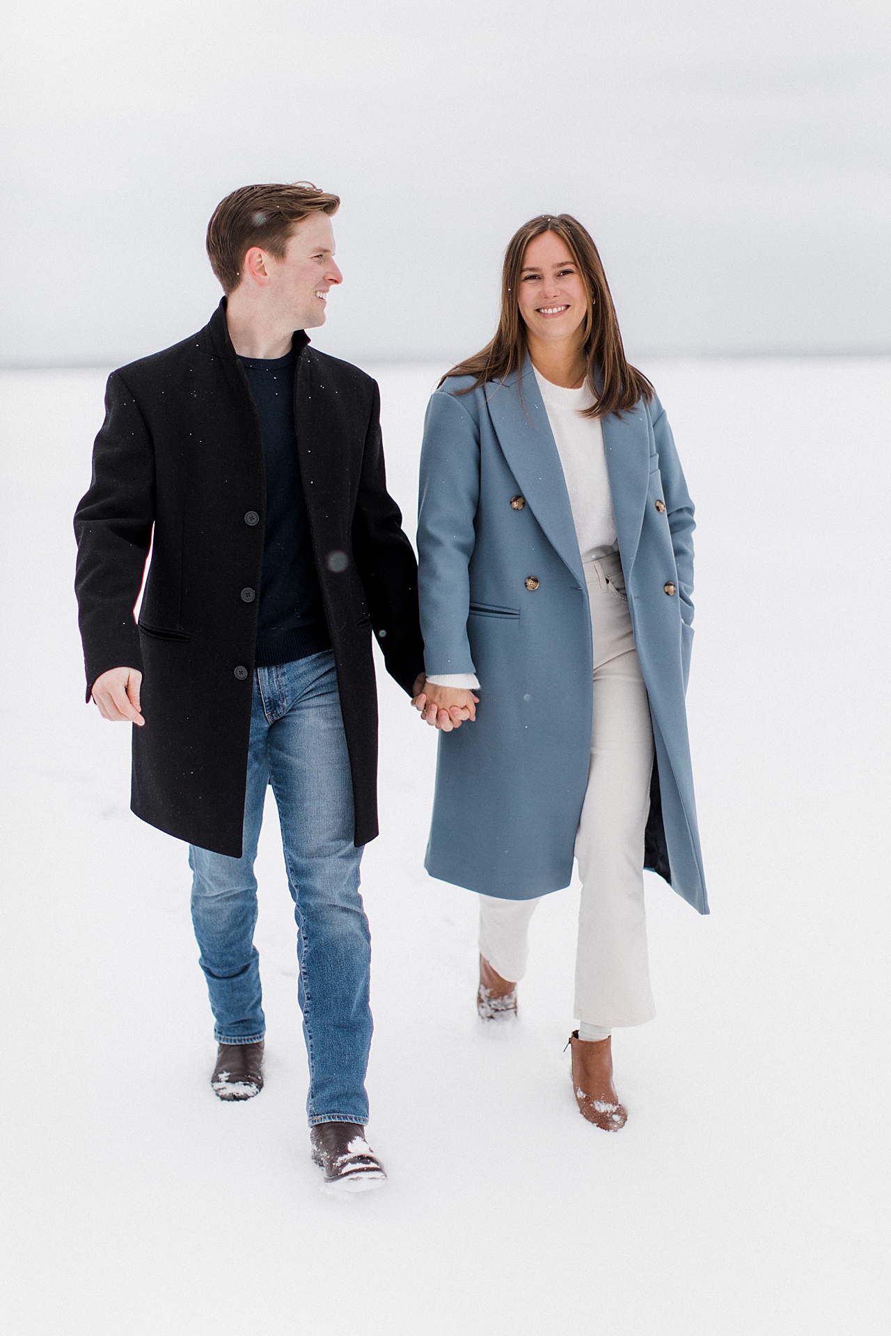 A couple walking hand in hand on a frozen lake in the winter