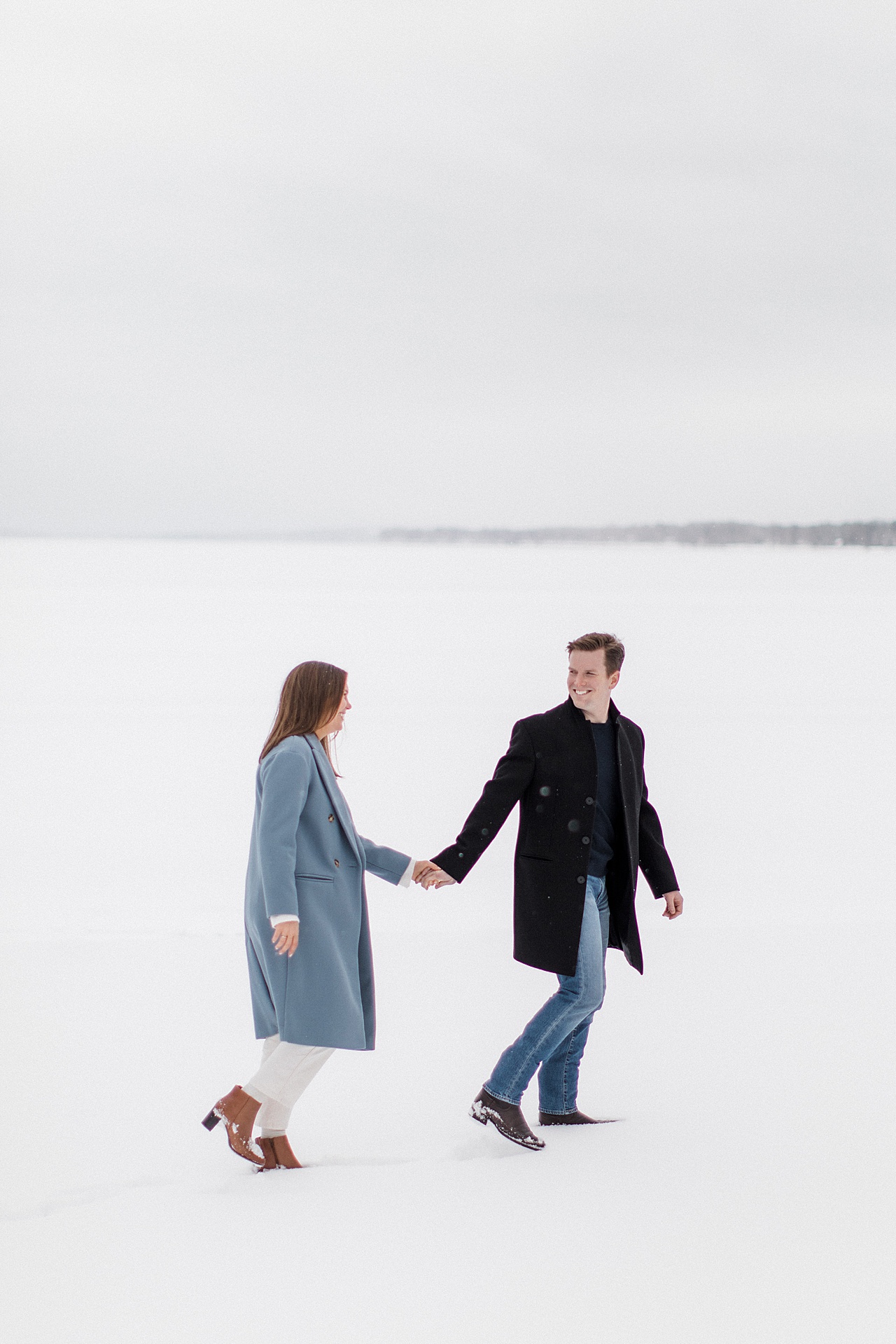 A couple walking on Mullett lake in Cheboygan, Michigan in the winter