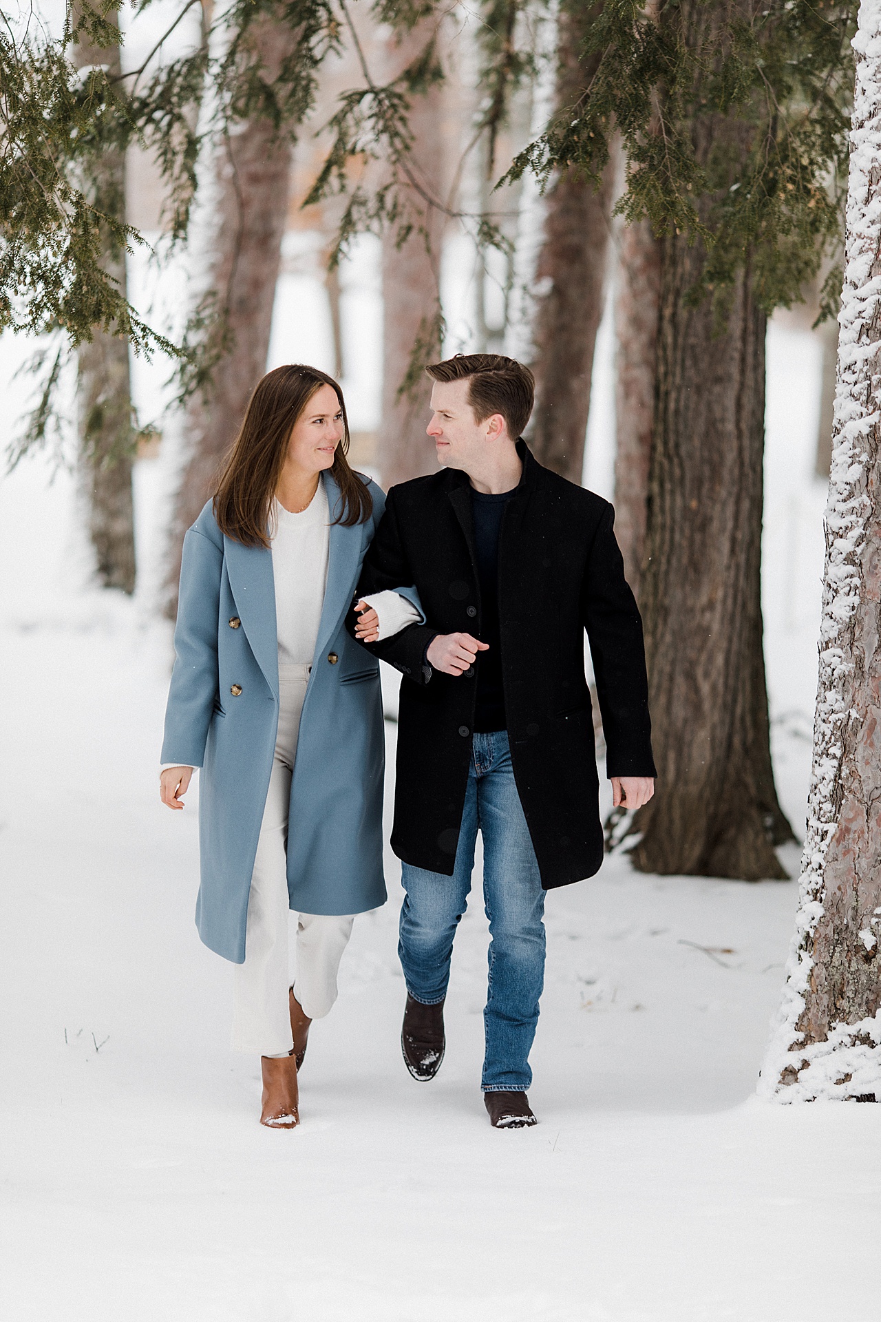 A couple walking through the woods in the winter