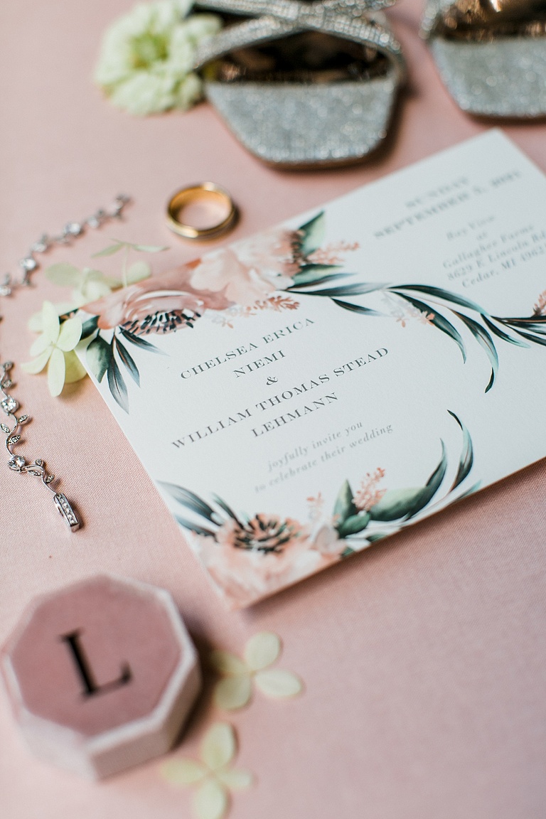 A wedding invitation set on a pink background
