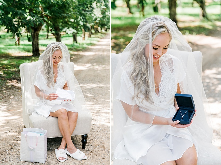 A bride opening a gift from her groom in a sunny orchard in Traverse City, Michigan