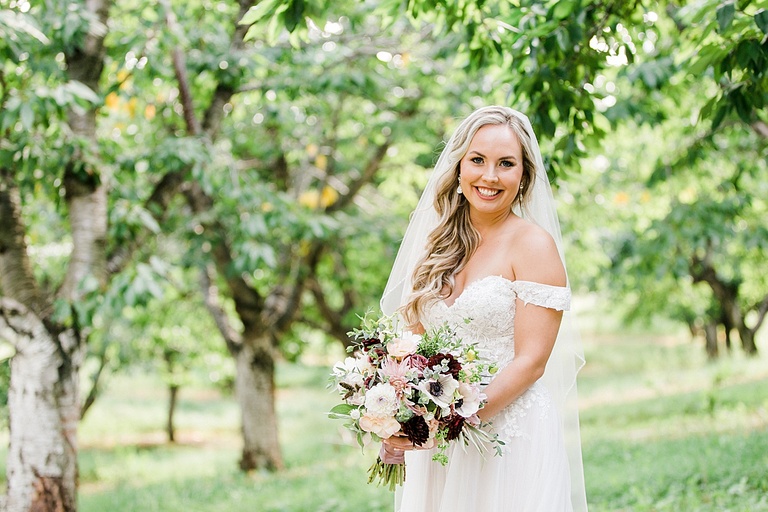 A bride smiling on her wedding day at Gallagher Farms orchard in Michigan
