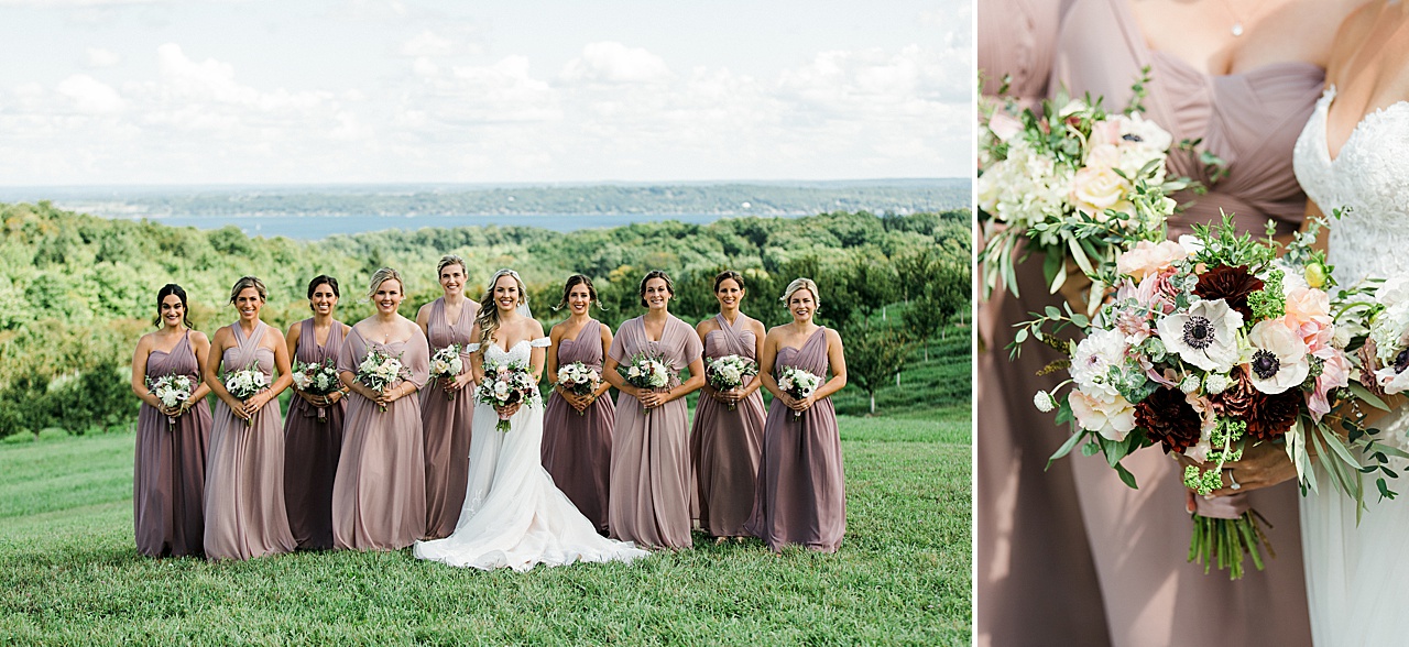 A bride and bridesmaids taking portraits on a grassy hill overlooking Grand Traverse Bay in Traverse City, Michigan