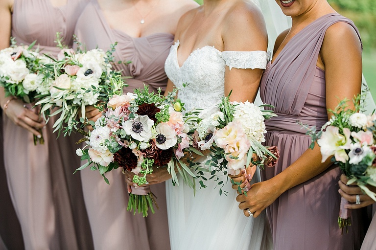 Brides and bridesmaids bouquets with white, pink, and burgundy flowers