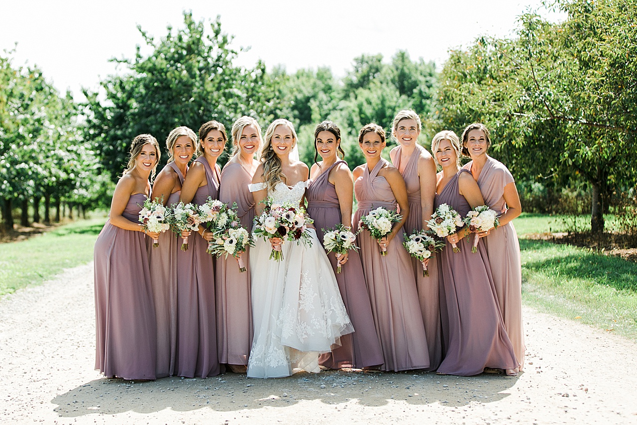 A bride and bridesmaids taking portraits on a sunny day in Northern Michigan