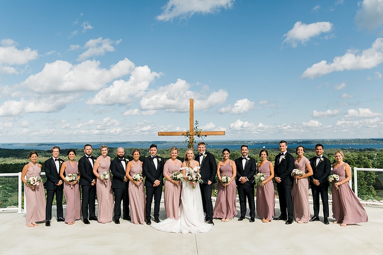 A portrait of a large bridal party with Grand Traverse Bay in Traverse City, Michigan in the background