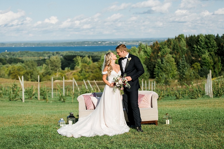 A bride and groom looking at each other on a bluff overlooking the Leelanau Peninsula