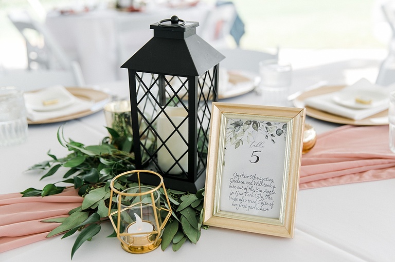 Reception table numbers, greenery, and lanterns