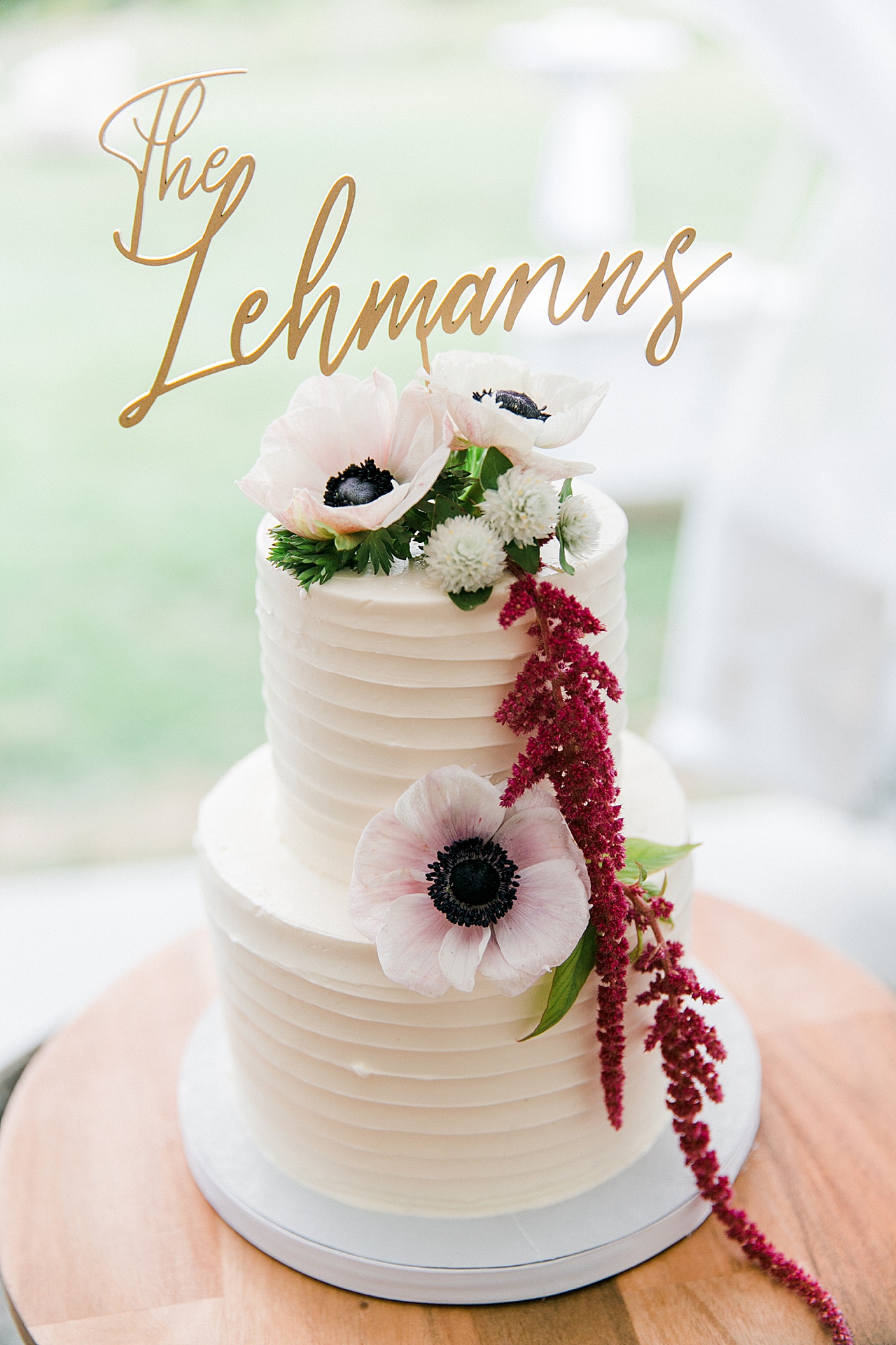 A white wedding cake with the bride and grooms last name at the top