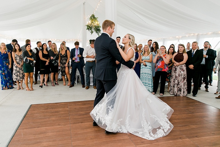 A groom twirling his bride during their first dance at their wedding reception