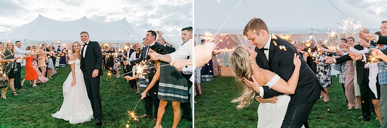 A bride and groom surrounded by sparklers that their guests are holding while kissing