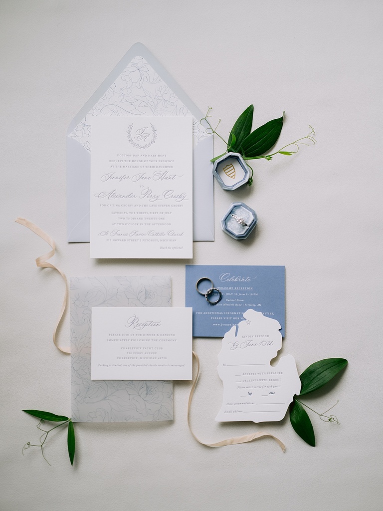 A photo of a classic look invitation suite with ribbon and greenery as accents