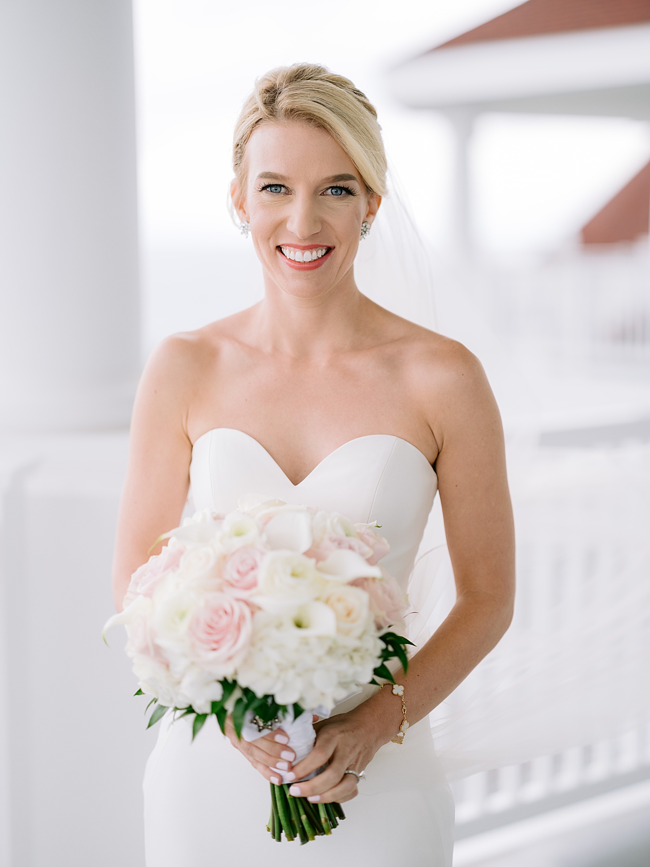 Portrait of a bride holding her bouquet and smiling in her wedding gown