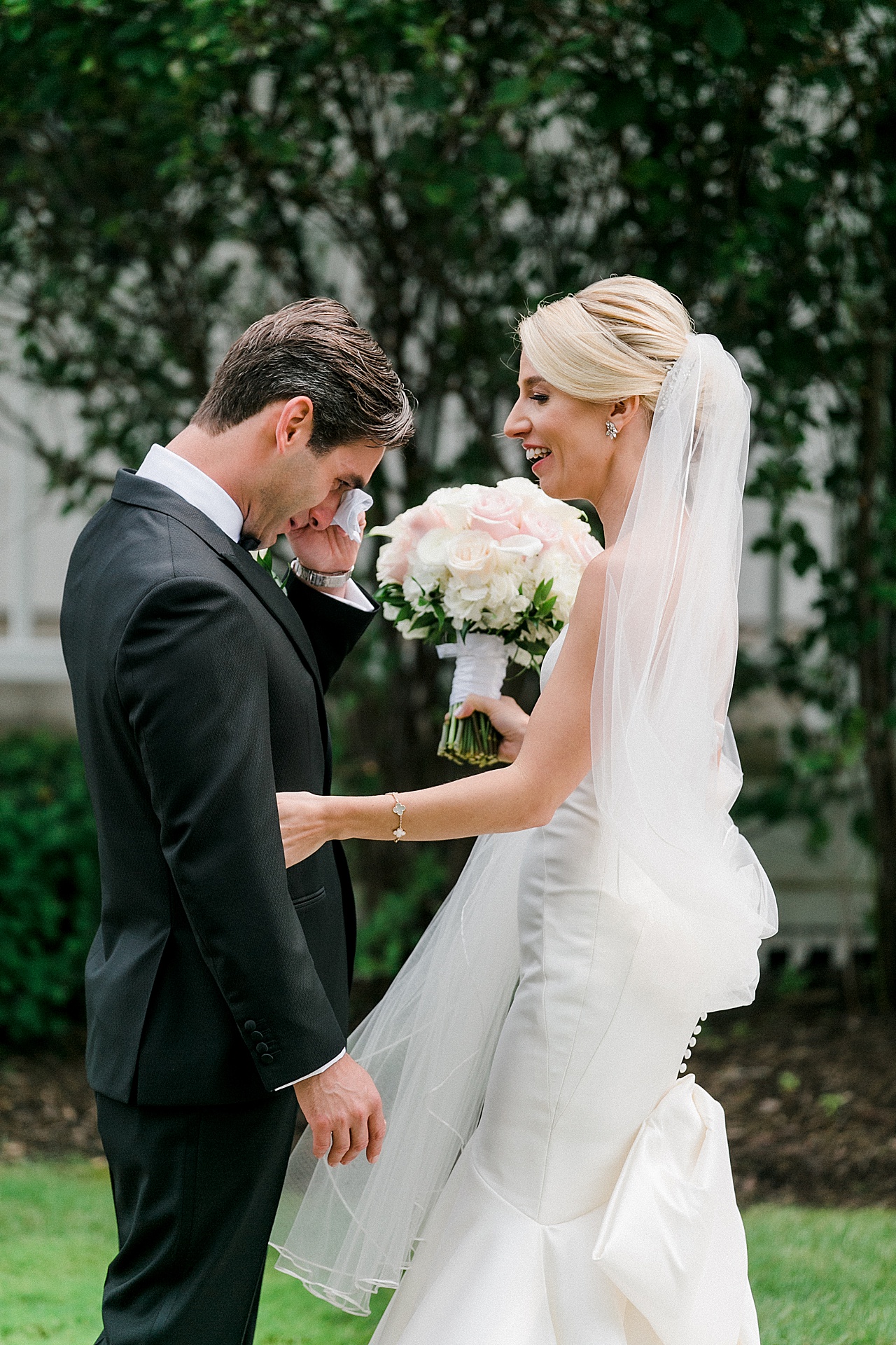 A groom wipes his eyes after seeing his bride in first look in Petoskey, Michigan