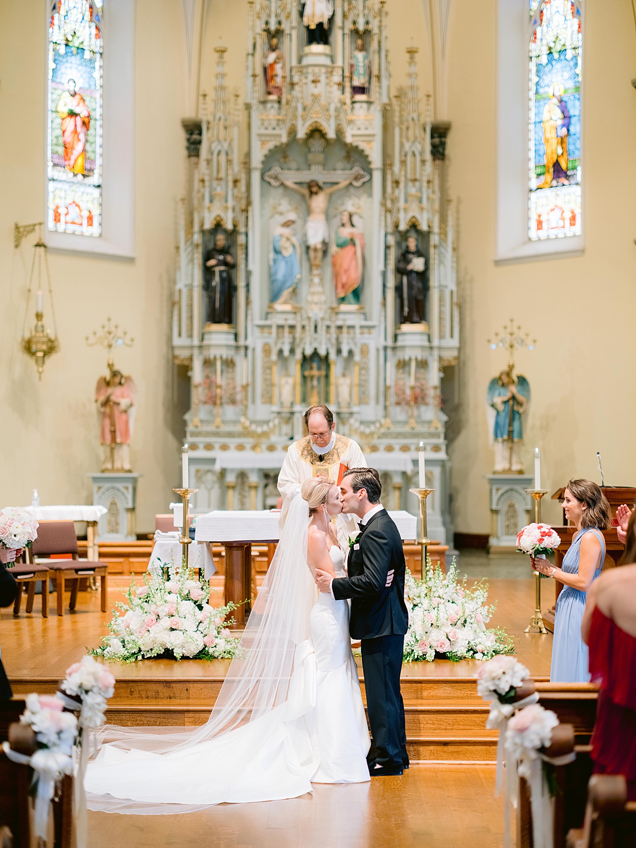 A bride and groom share their first kiss as a wedded couple in a cathedral