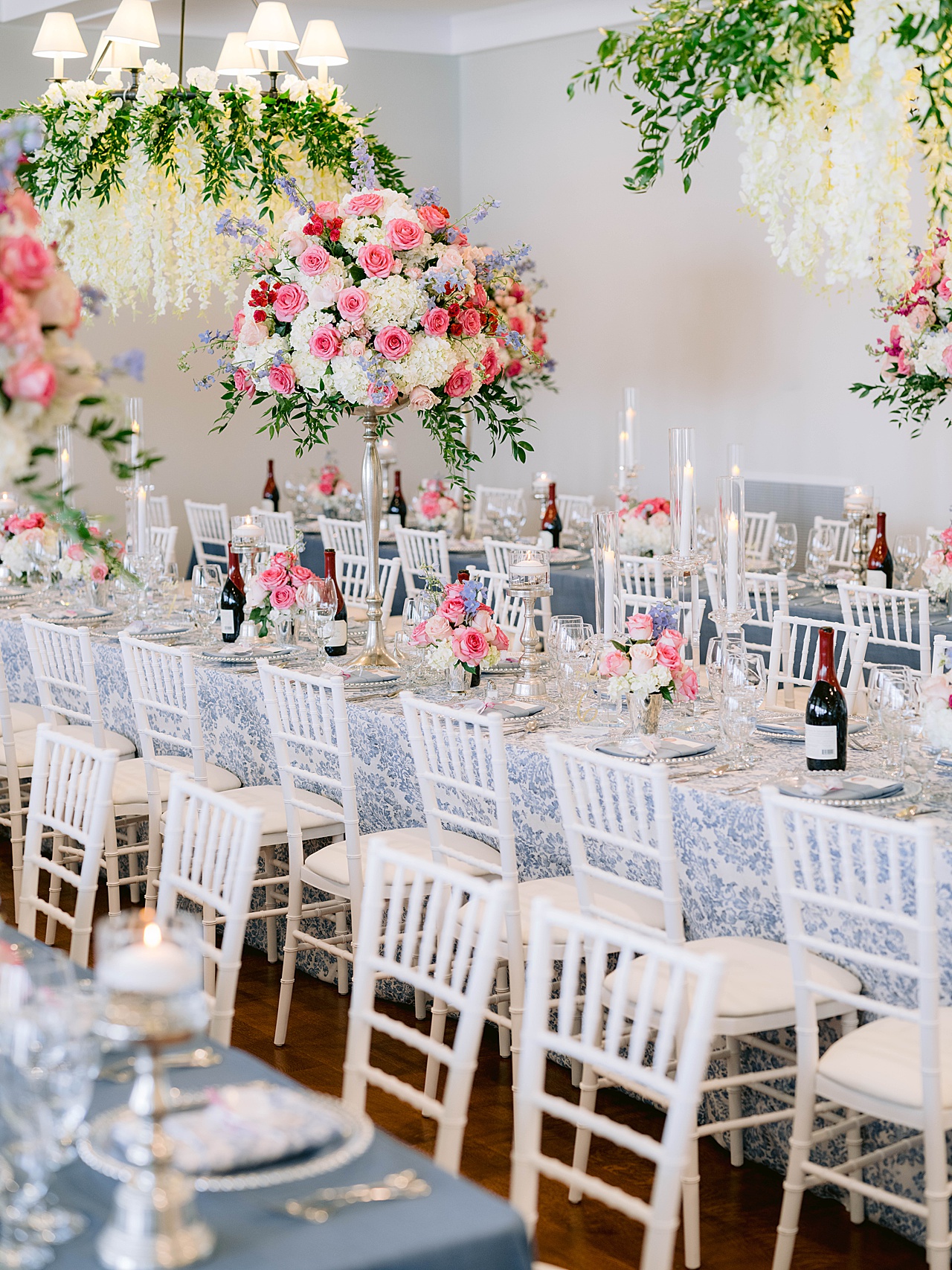 A white and blue themed reception with tall, pink floral pieces in Northern Michigan
