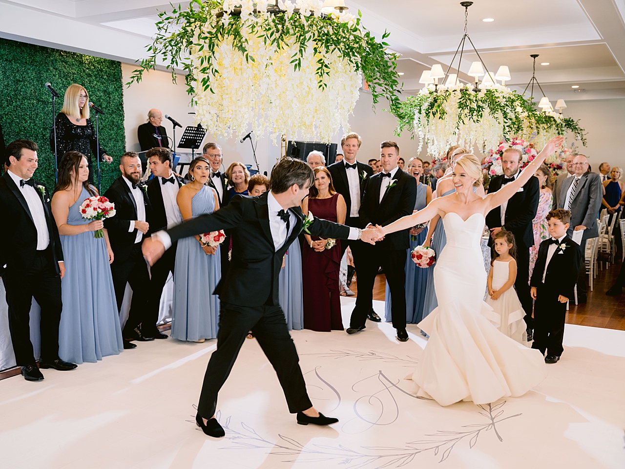 A bride and groom dancing at a reception in Michigan while wedding guests watch